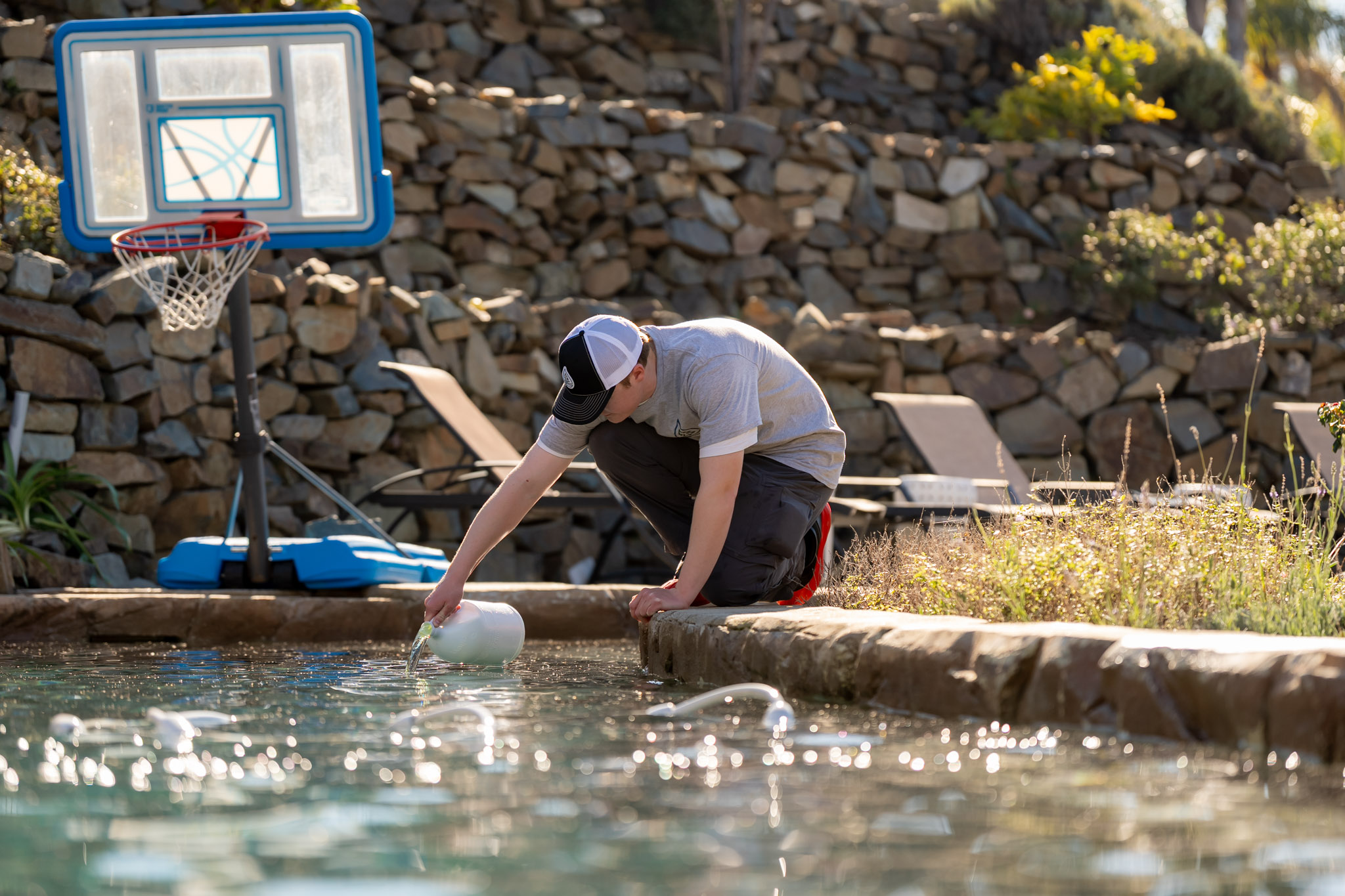 Woody's Pools tech adding chemicals to balance pool water